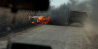 Blick aus einem Fahrzeug auf ein brennendes Auto nahe der Front