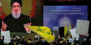 Menschen jubeln Hisbollah-Chef Nasrallah zu, der auf einem riesigen Bildschirm zu sehen ist