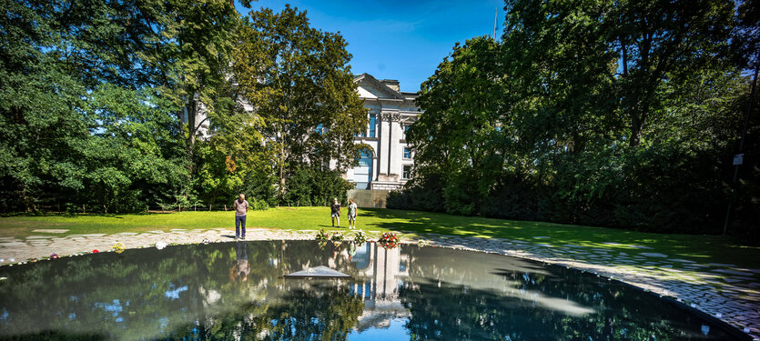 Blick auf das von Bäumen umgebene Denkmal für die von den Nazis ermordetenen Sinti und Roma in Berlin