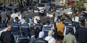 Demonstrierende Journalisten tragen leere Särge