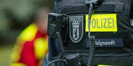 Nahaufnahme eines Berliner Polizisten, der eine Bodycam an der Weste trägt