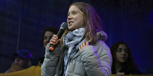 Greta Thunberg trägt ein Pali-Tuch und spricht in eine Mikrofon