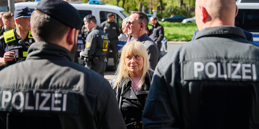 Das Bild zeigt Innensenatorin Spranger im Kreis von Polizisten