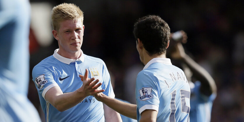 Kevin de Bruyne klatscht mit einem Mitspieler ab.