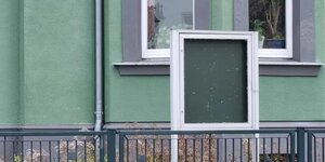 Ein leerer Schaukasten vor einem Haus mit grüner Wand