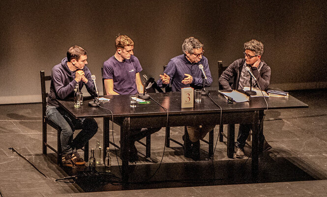 An einem Tisch auf der Bühne sitzen Geoffroy de Lagasnerie, Didier Eribon, Éduard Louis und Sonja Finck