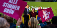 Menschen halten Schilder mit "Alle Stimmen Grün" hoch, auf der Bühne davor stehen Katharina Schulze, Ludwig Hartmann und Ricarda Lang