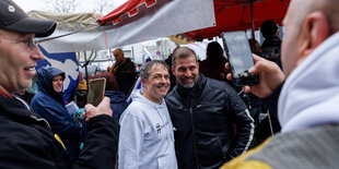 Michael Ballweg und Björn Banane posieren Arm in Arm für ein Foto im April 2023 in Stuttgart-Stammheim.