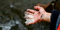 Hand eines Klimaktivisten, von der sich der Klebstoff löst