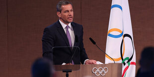 Michael Mronz vor der Olympischen Flagge