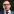 Ladislav Harmann trägt kurze Haare, Brille und einen bläulichen Anzug mit passender Krawatte und weißem Hemd