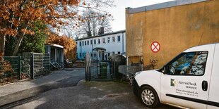 Ein weißer Wagen mit Aufschrift Sternipark vor einem Hof mit weißem Gebäude