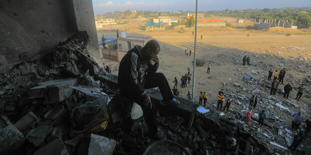 Ein Mann sitzt verzweifelt in einem zerbombten Haus in Khan Yunis im Gazastreifen