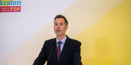 Christian Dürr spricht vor der Medienwand der FDP im Bundestag