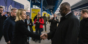 Eine Frau schüttelt Lloyd Austin die Hand