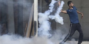 Junger Palästinenser wirft Tränengaskartusche zurück
