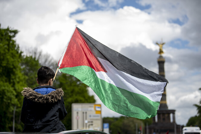 Ein Junge hält während dem Autokorso unter dem Motto «Solidaritätsfahrt mit Gaza, Jerusalem und Sheikh Al Jarrah» am großen Stern eine Palästinenser-Flagge in der Hand