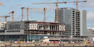 Einsatzfahrzeuge der Feuerwehr stehen nach dem Unfall auf der Baustelle in der Hamburger Hafencity.