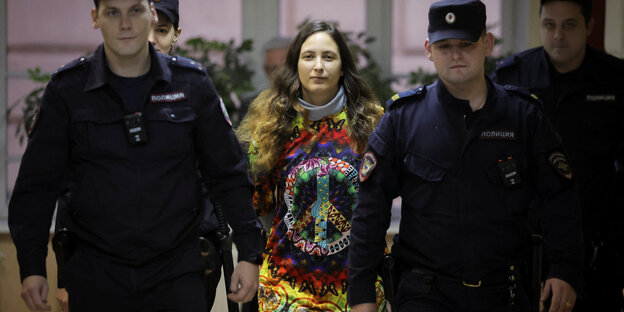 Die Künstlerin Sasha Skochilenko wird von Polizisten in den Gerichtssaal eskortiert