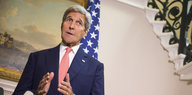 Kerry steht vor einer USA-Flagge und redet zur Presse