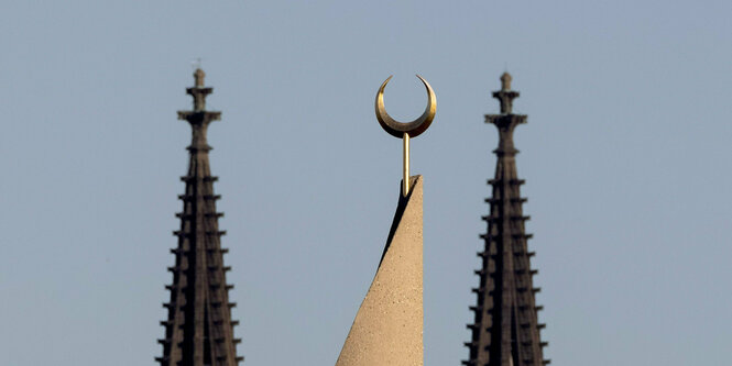 Spitzen einer Moschee und einer Kirche.