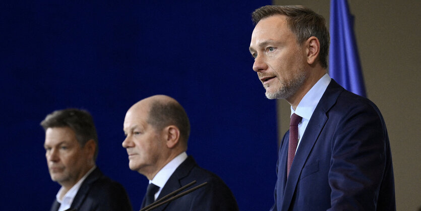 Wirtschaftsminister Robert Habeck, Kanzler Olaf Scholz und Finanzminister Chrisian Lindner an Rednerpulten