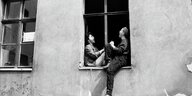 Zwei Frauen sitzen einander gegenüber im Fenster