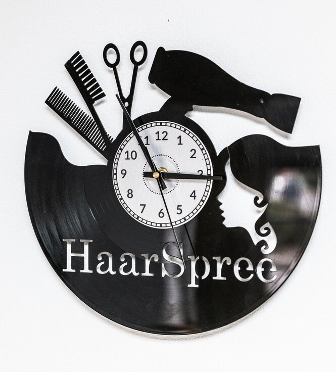 Uhr in Form einer Schallplatte mit Friseurutensilien und der Schrift Haarspree