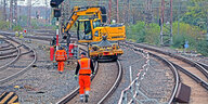 Arbeiten an Gleisanlagen - Bauarbeiter und Kranfahrzeug auf den Gleisen