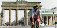 Ein Radfahrer mit Gesichtsmaske in der Nähe des Brandenburger Tors