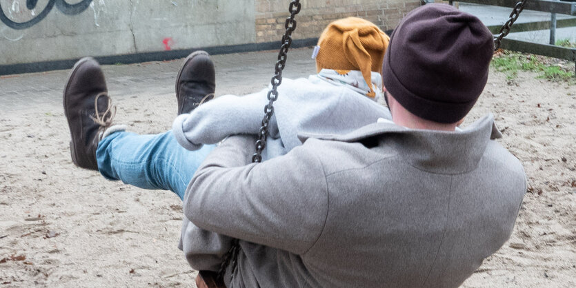 Ein Vater mit seinem Kind auf einer Schaukel