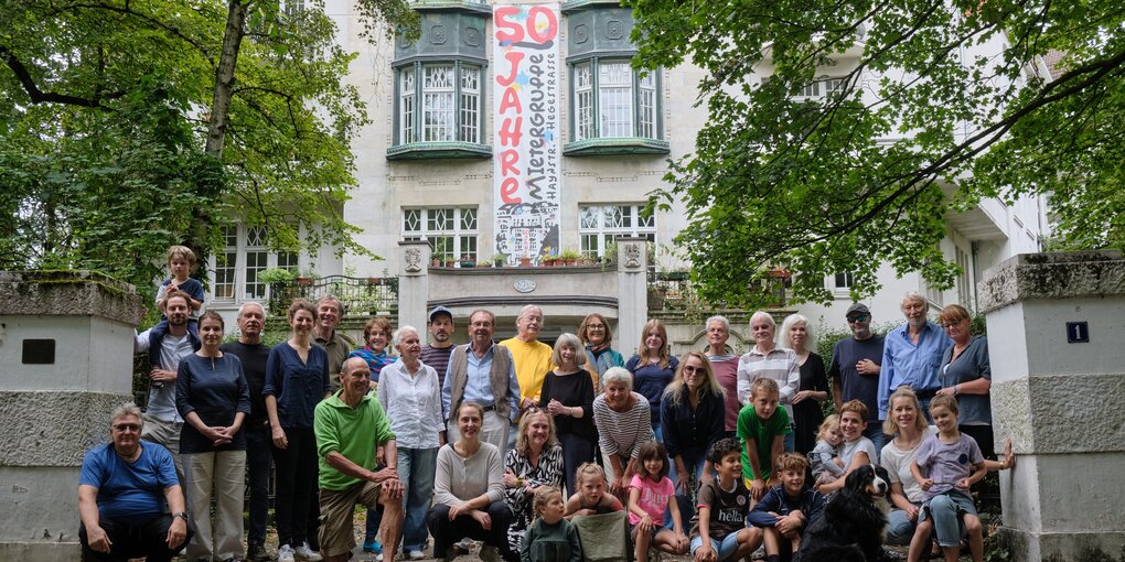 Gruppenfoto Bewohner stehen vor einem schönen Altbau