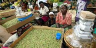 Frauen verkaufen frische Grashüpfer auf einem Markt in Kampala