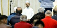 Ein Imam in weißen Gewand betet vor