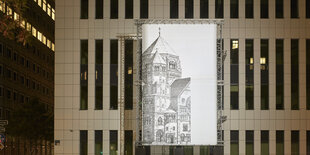 Eine Leinwand vor der Fassade eines Bürogebäudes in Düsseldorf zeigt die Umrisse der einstigen, während der Novemberpogrome 1938 zerstörten Zentralsynagoge in Düsseldorf