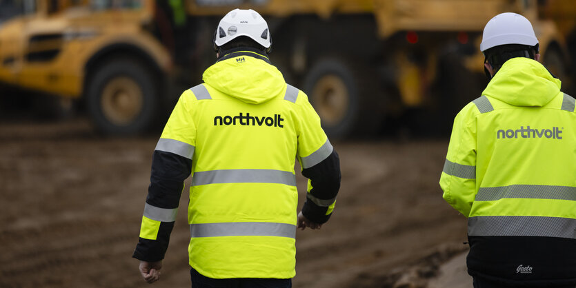 Zwei Mitarbeiter der Firma Northvolt gehen über eine Baustelle der Batteriefabrik im Kreis Dithmarschen.