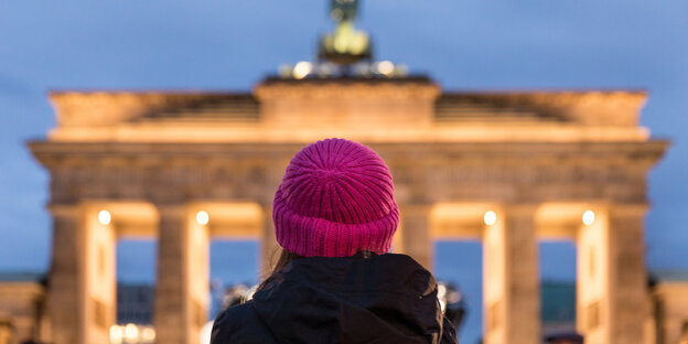 Demonstrantin mit pinker Mütze vor dem Brandenburger Tor