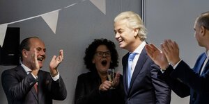 Der niederländische Rechtspopulist Geert Wilders geht am Tag nach seinem Wahlsieg lächelnd durch eine Gruppe von Unterstützer:innen.
