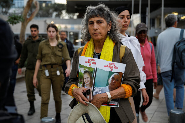 Eine Frau hält ein Schild mit dem Foto zweier entführter Israelis