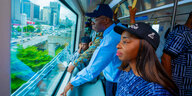 Einweihung des Zuges der Blue Line in Nigeria Reisende schauen aus dem Fenster auf Hochhäuser und Straßen in Lagos