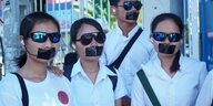 Vier Umweltaktivisten von Mother Nature Cambodia protstieren mit zugeklebten Mündern.