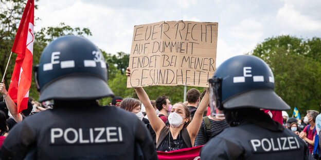 Eine Demonstrantin hält ein Schild mit der Aufschrift "Euer Recht auf Dummheit endet bei meiner Gesundheit".