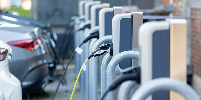 Mehrere Ladesäulen, über die gerade über einen Kabelanschluß Elektroautos aufgeladen werden.