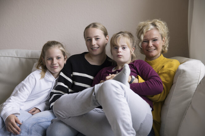 Natascha Zaminski und ihre Töchter sitzen auf einem Sofa.