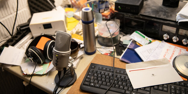 Ein Radiomikrofon und anderes Zeug auf einem Bürotisch
