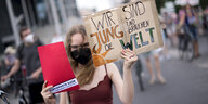 Junge Klimaaktivistin mit Demonstrationsschild "Wir sind junge und brauchen die Welt"
