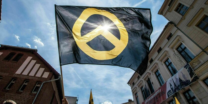 Flagge der Identitären - der griechische Buchstabe Lambda in Gelb auf schwarzenm Grund weht vor dem ehemaligen Haus der Gruppierung