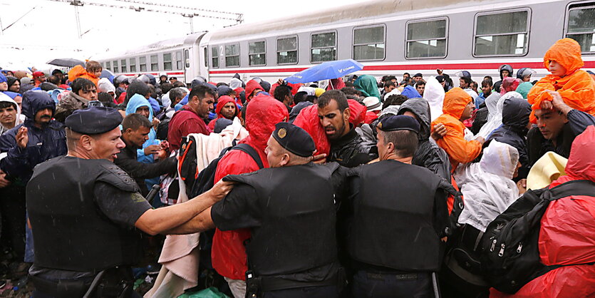 Menschenmenge rangelt mit Polizei auf einem Bahnsteig