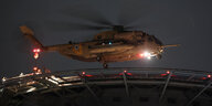 Ein Helikopter in der Nacht bei der Landung.