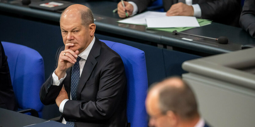 Olaf Scholz beugt sich in das Kameramotiv